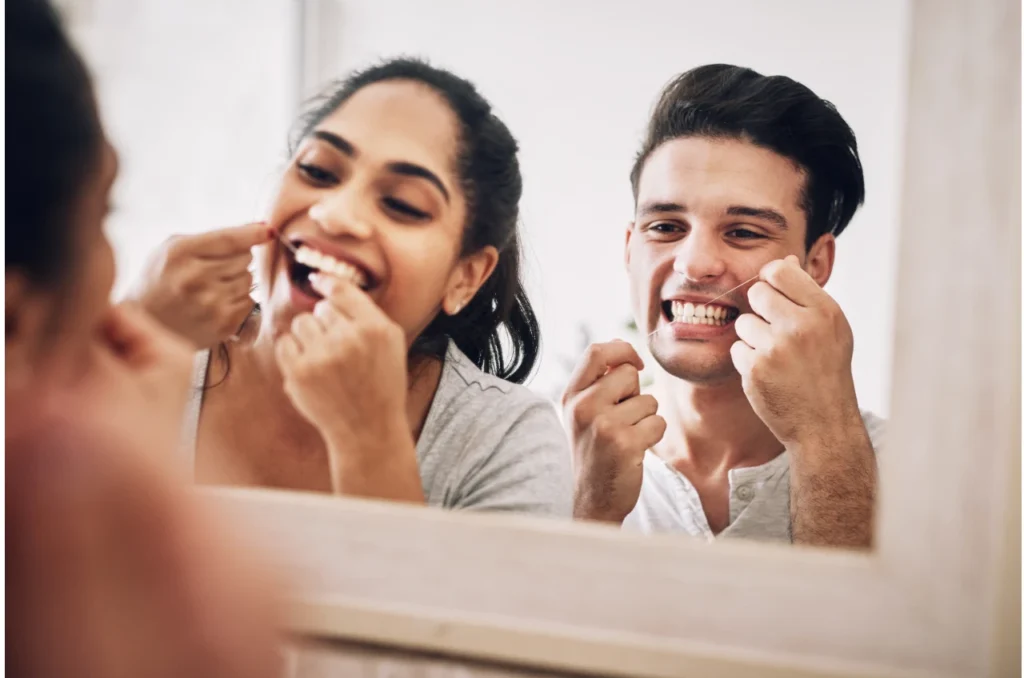 Casal Em Frente Ao Espelho Passando Fio Dental Nos Dentes